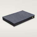 Flat dog mattress bed with a grey plush top on a black base