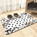 White cat mat printed with cartoon cats and black paw prints under a raised two-bowl stand on a wood floor