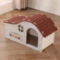 White felt cat house with a red-brown scalloped roof, round window and arched doorway on a wooden floor