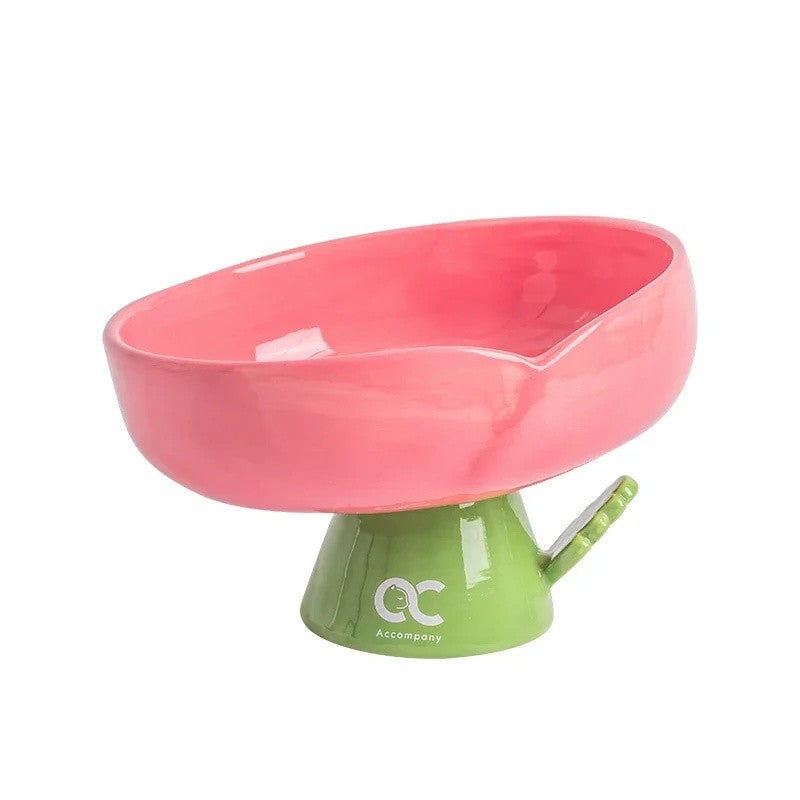 Pink ceramic flower cat bowl with a tilted rim on a green stem pedestal