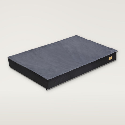 Flat dog mattress bed with a grey plush top on a black base