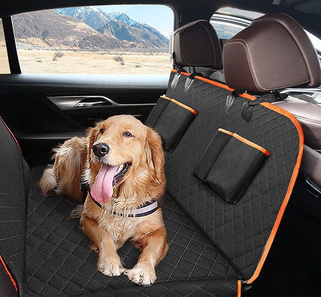 A golden retriever lying on the orange-trimmed quilted cover, two pockets on the backrest