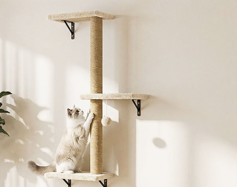 Jute post with plush boards and a hanging pom-pom; a ragdoll cat scratches the post