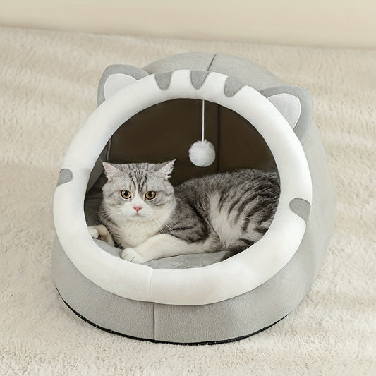 Grey and white cat-ear cave with a round opening and a hanging pom toy, a tabby cat lying inside