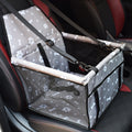 Grey car booster box with white paw and bone prints and a mesh front, hung on a car seat