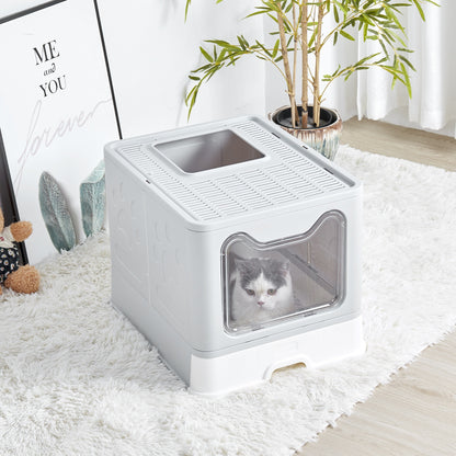 Grey enclosed litter box on a white rug with a cat looking out through the clear door