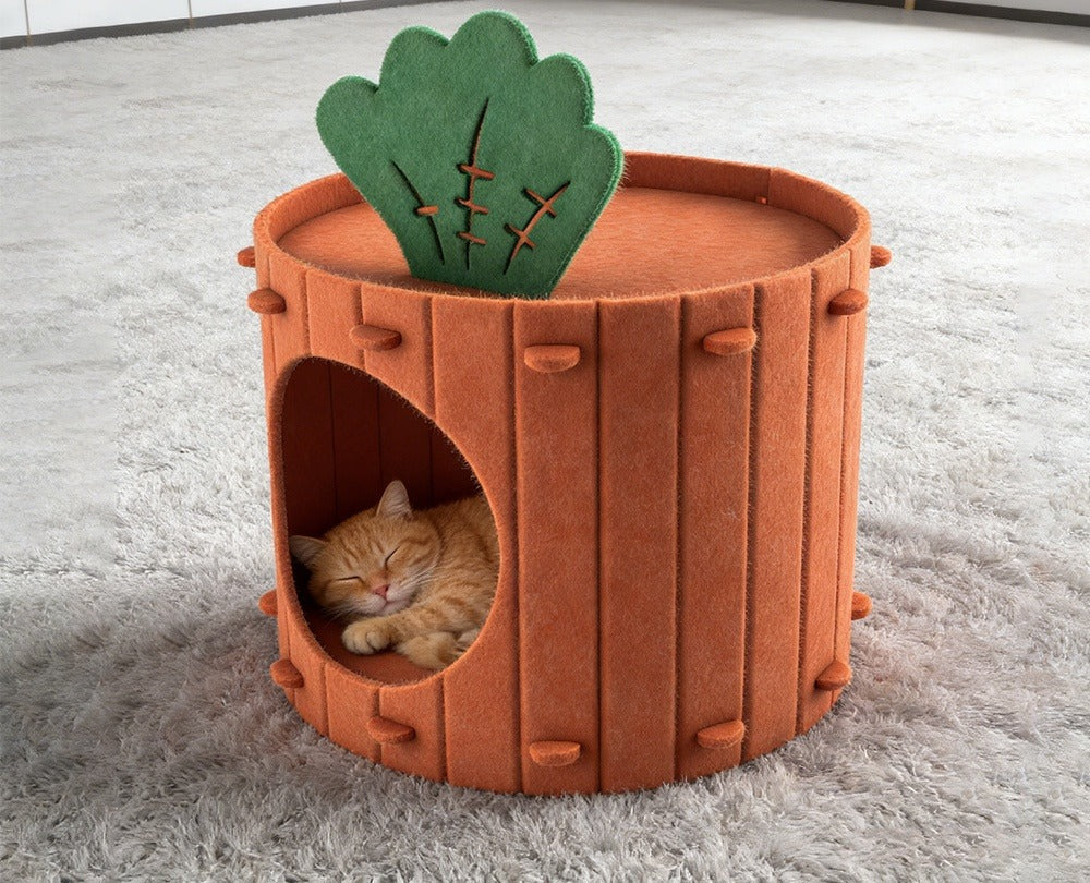 Orange felt carrot cave with a green leaf on a grey shaggy rug, an orange tabby asleep inside