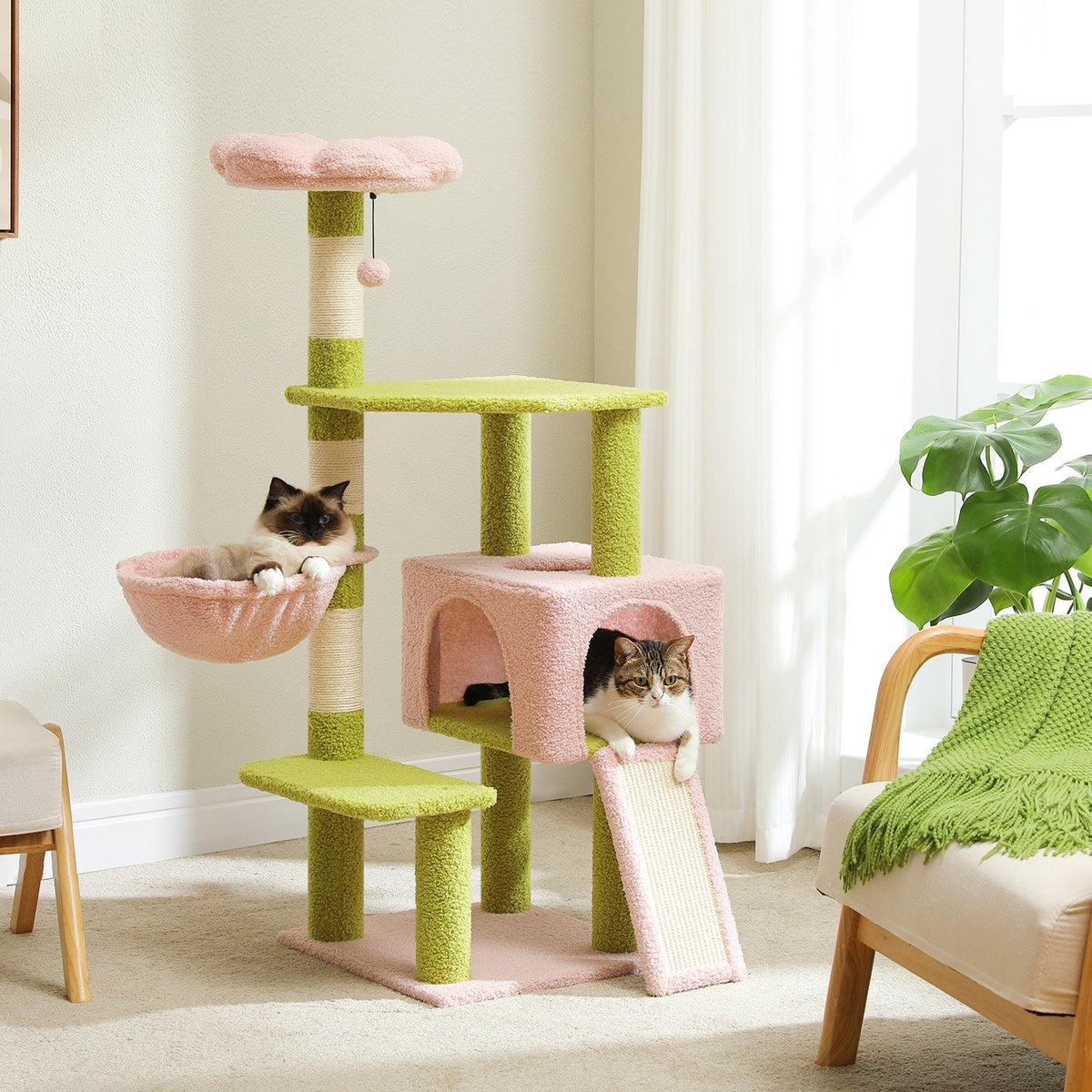 Green and pink flower cat tree in a bright living room with cats in the basket and the condo