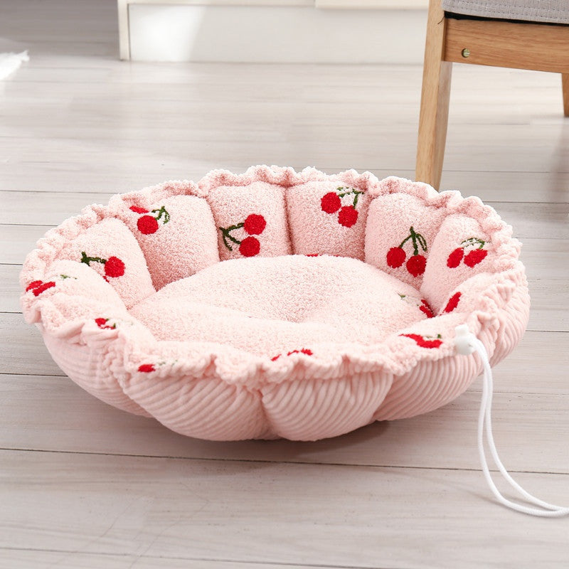 Round petal-shaped plush cat nest, pink with red cherry motifs, with a white drawstring