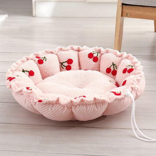 Round petal-shaped plush cat nest, pink with red cherry motifs, with a white drawstring