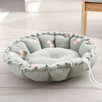 Round petal-shaped plush cat nest, mint green with pink fruit motifs, with a white drawstring