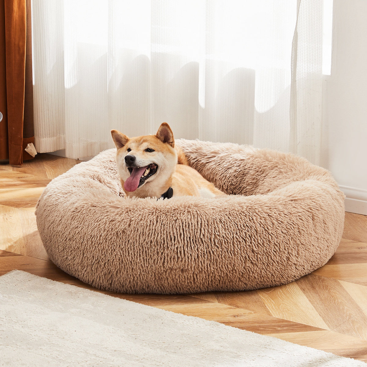 Tea brown round faux-fur donut dog bed with a shiba sitting in it by a window